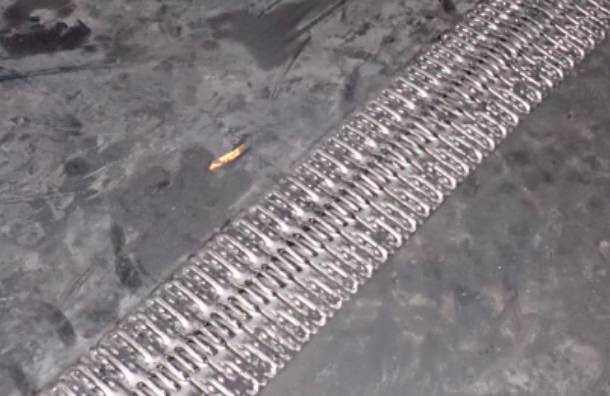 Heavy-duty conveyor belt showing MATO fastener splice installed in rugged black rubber.