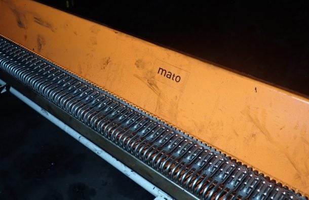 MATO conveyor belt fastener system installed on site featuring spring tensioners and orange guard plate